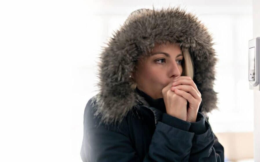Woman With Warm Clothing Feeling The Cold Inside House
