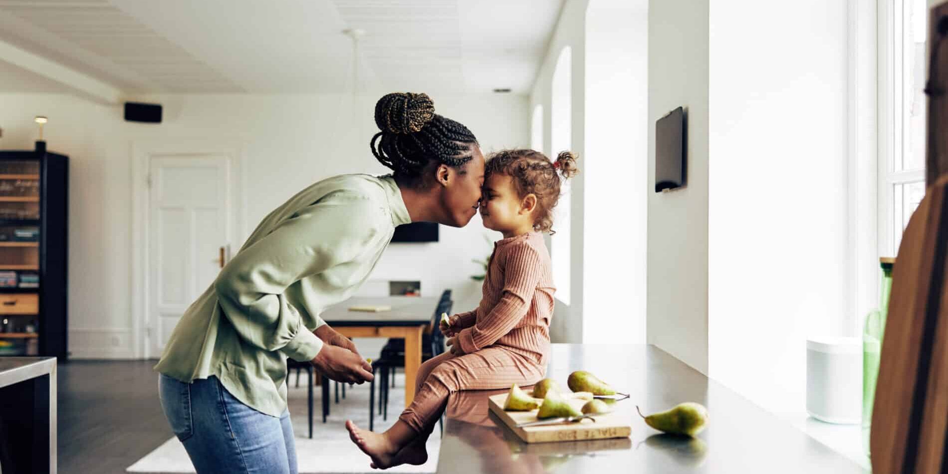 Loving mom and her little girl having a snack at home